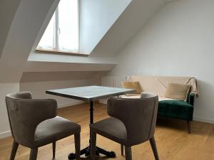 um quarto com uma mesa e duas cadeiras e um sofá em Paris - Notre Dame - Panthéon - Luxembourg - 30 m2 em Paris