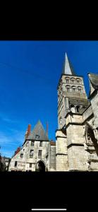 een oud stenen gebouw met een toren met een blauwe lucht bij maison ancienne rénovée tout confort in Narcy