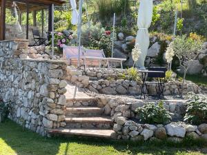 eine Steinmauer mit einer Bank und einer Steintreppe in der Unterkunft Casa Natura 40 in Parghelia