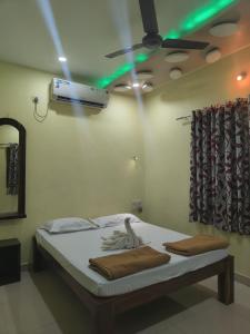 una camera con letto e ventilatore a soffitto di Konkan Villa Dream a Malwan