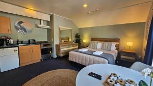 um quarto de hotel com uma cama e uma cozinha em Franz Josef Montrose Lodge em Franz Josef