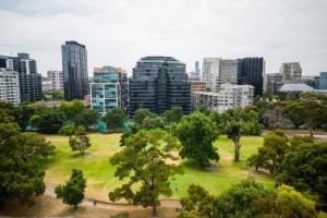 ein Park mit Bäumen und Gebäuden in einer Stadt in der Unterkunft Luxury Melbourne with Albert Park Views in Melbourne