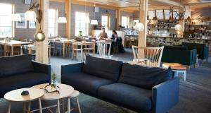 a restaurant with couches and tables and a bar at Tännäskröket in Tännäs