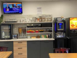 a kitchen with a counter with a refrigerator and a microwave at Fasthotel Soissons Nord in Soissons