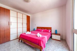 a bedroom with a large red bed with pink pillows at Zoilen in San Pietro in Bevagna