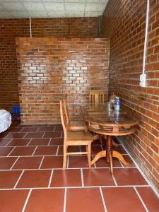 a brick wall with a wooden table and chairs at Chau Doc Homestay in Chau Doc