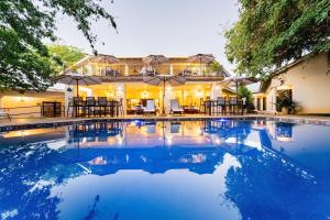 una piscina frente a una casa en Nkosi Guest Lodge en Victoria Falls