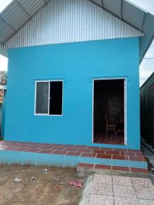 a blue building with a chair in front of it at Chau Doc Homestay in Chau Doc