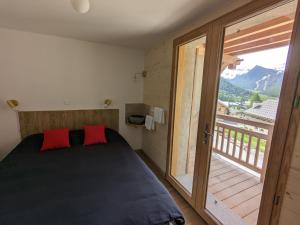 um quarto com uma cama e uma grande janela em chalet panoramique em Ceillac
