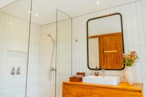 a bathroom with a sink and a mirror at Villa Avocagolf Uluwatu by Nakula in Badung