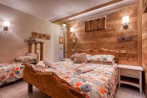 a bedroom with a bed with a wooden wall at L'Arbergh Palanfrè in Vernante
