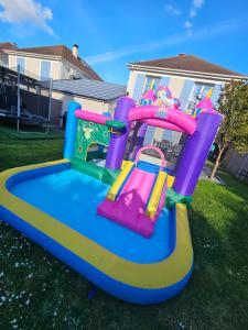 a colorful inflatable bounce house in a yard at 135m2 - Villa, 5 min to the park - DISNEY MAGICAL HOMES, PARIS in Magny-le-Hongre