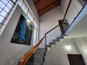 a staircase in a house with a painting on the wall at Charvi Villa Stay - 3BH, Home Food, Campfire in Chikmagalūr