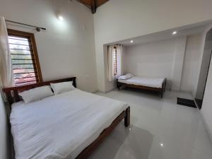 a bedroom with a bed and a bench in it at Charvi Villa Stay - 3BH, Home Food, Campfire in Chikmagalūr