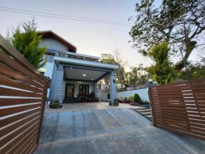 Casa con valla de madera y entrada en Charvi Villa Stay - 3BH, Home Food, Campfire, en Chikmagalur