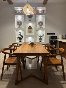 une salle à manger avec une table et des chaises en bois dans l'établissement Villa Erita, stylish and beautiful villa in Nyang Nyang, à Uluwatu