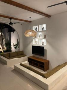 un salon avec une télévision à écran plat sur un mur dans l'établissement Villa Erita, stylish and beautiful villa in Nyang Nyang, à Uluwatu
