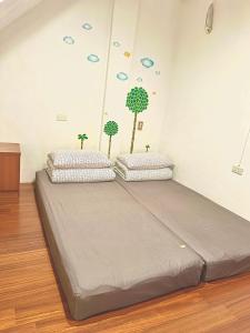 1 cama en una habitación con 2 árboles en la pared en One House, en Gongliao