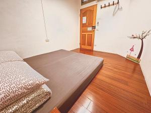 a bedroom with a bed and a wooden floor at One House in Gongliao