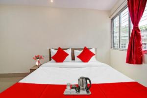 1 dormitorio con 1 cama blanca grande con almohadas rojas en GRG Vhyom Sky Palace Near Metro Station Kolkata, en Calcuta