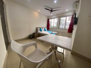 een woonkamer met een tafel en stoelen en een bank bij GRG Vhyom Sky Palace Near Metro Station Kolkata in Calcutta