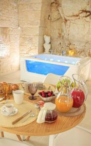 un tavolo con frutta e verdura e una piscina di GB Grotta Bianca a Ostuni
