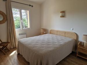 1 dormitorio con cama blanca y ventana en Villas Abbartello, en Olmeto