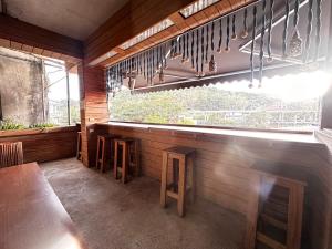 a restaurant with a table and stools in front of a window at One House in Gongliao