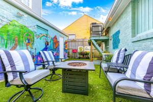 a patio with chairs and a fire pit with a mural at Mardi Gras Patio 2BR 8mins to Canal St in New Orleans