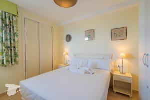 1 dormitorio con 1 cama blanca y 2 mesitas de noche en CostaBlancaDreams Esmeralda Suites in Calpe, en Casas de Torrat