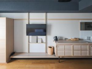 a kitchen with a cabinet and a tv on the wall at Vessel Hotel Campana Susukino in Sapporo