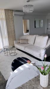 ein Wohnzimmer mit einem weißen Sofa und einem Tisch in der Unterkunft Oxygen Home in Nyíregyháza
