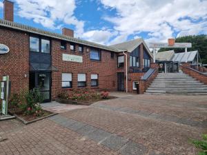 a brick building with a staircase in front of it at Sporthotel Papenburg in Papenburg