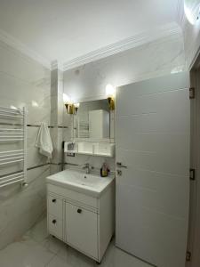 a white bathroom with a sink and a mirror at Vinland Villa Atalar in Trabzon