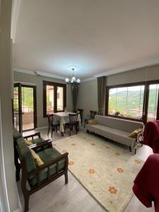 a living room with a couch and a table at Vinland Villa Atalar in Trabzon