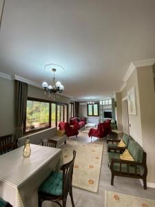 a living room with tables and chairs and a couch at Vinland Villa Atalar in Trabzon