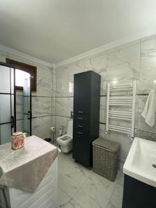 a bathroom with a toilet and a sink and a black cabinet at Vinland Villa Atalar in Trabzon