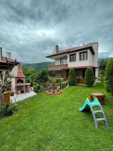een groot huis met een tuin met een speeltuin bij Vinland Villa Atalar in Trabzon