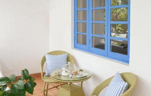 stół, 2 krzesła i niebieskie okno w obiekcie Soul Vacation Resort and Spa,Colva w mieście Colva