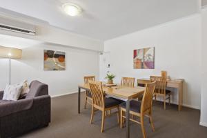 a living room with a table and chairs and a couch at Spacious Apt in Northbridge with Pool in Perth
