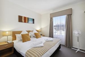 a hotel room with a bed and a window at Spacious Apt in Northbridge with Pool in Perth +26 photos