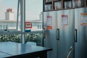 a room with three metal refrigerators with a table and a window at Garden Lane Backpackers in Dublin