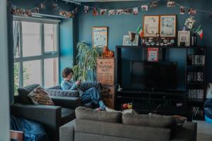 a boy sitting on a couch in a living room at Garden Lane Backpackers in Dublin