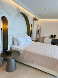 a bedroom with a large bed and a table at Naiades Boutique Hotel - Adults Only in Elounda