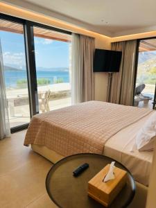 a hotel room with a bed and a table with a view at Naiades Boutique Hotel - Adults Only in Elounda