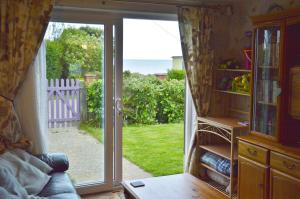 an open door to a patio with a view of the ocean at Dawn in Hemsby