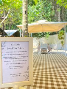 a sign in front of a table with a table cloth at Kama Siri Koh Kood in Ko Kood