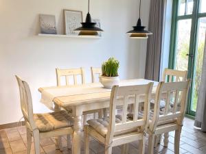 einen Esstisch und Stühle mit Pflanze drauf in der Unterkunft Ferienhaussiedlung Strandperlen Weidenhof 3b (Typ VI) in Wustrow