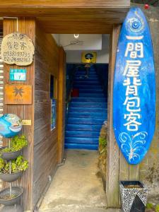 une planche de surf sur le côté d'un immeuble avec des escaliers dans l'établissement One House, à Gongliao