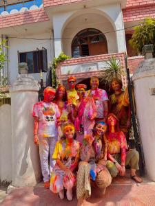 eine Gruppe von Personen, die vor einem Haus mit Farbe bedeckt sind in der Unterkunft JWALA JAIPUR in Jaipur